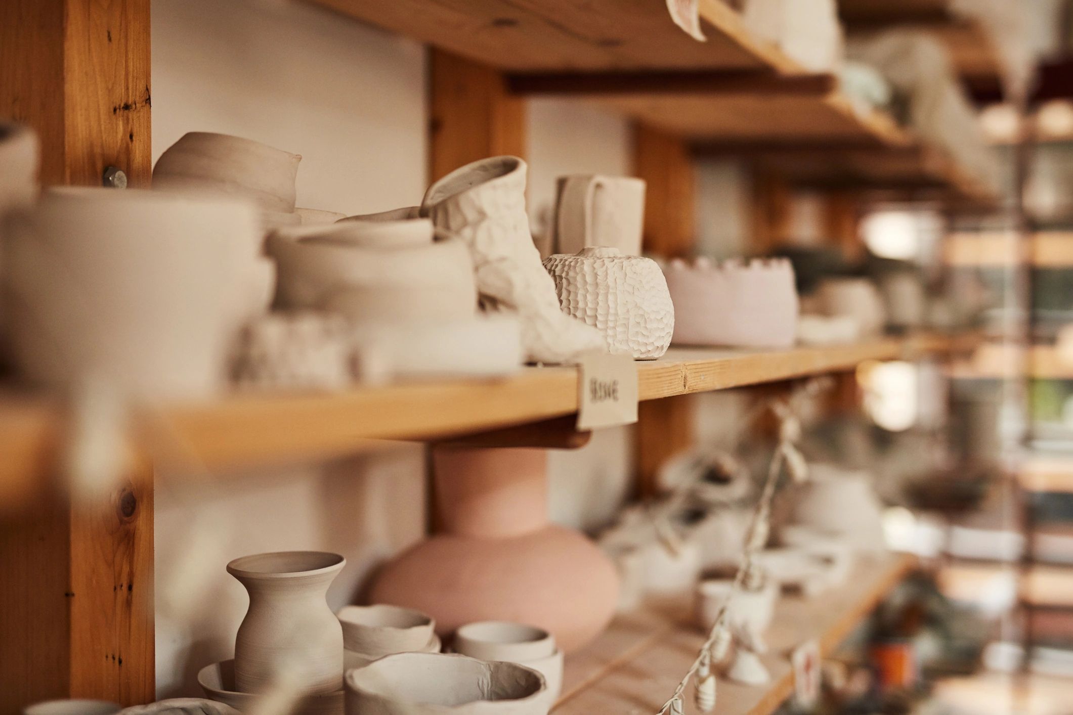 Handcrafted ceramic cups, pots, and bowls in a pottery workshop